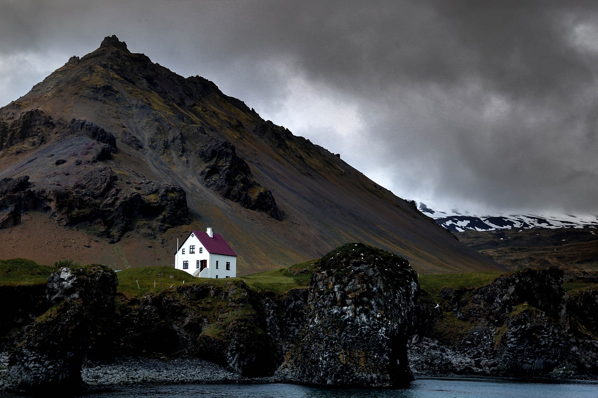 Einzelnes Haus vor einem Berg in Island