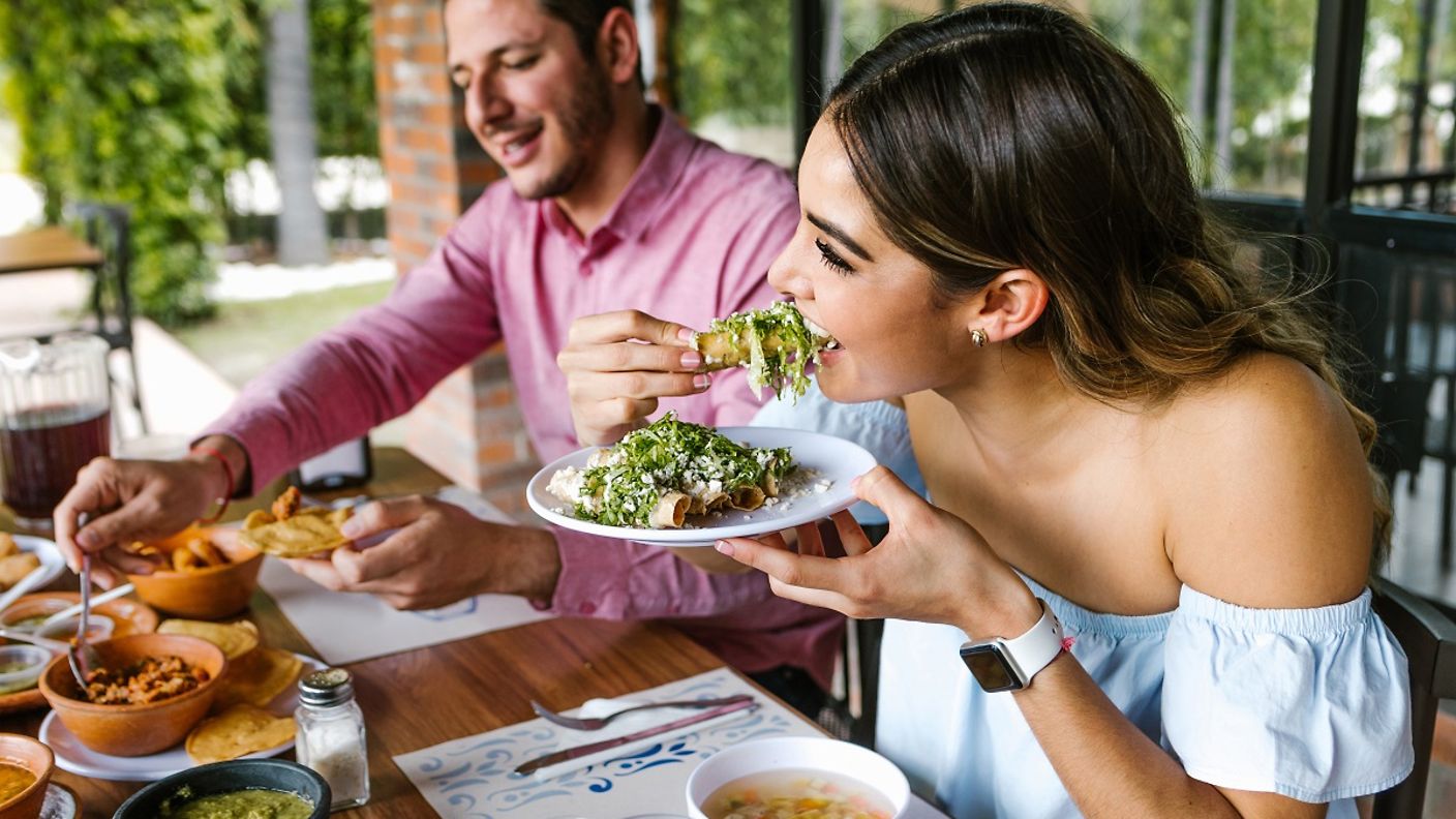Ein junges Paar isst Tacos in einem Restaurant in Mexico