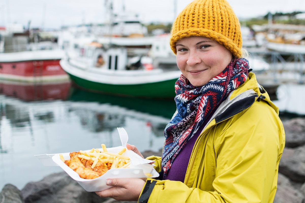 Frau isst am Hafen