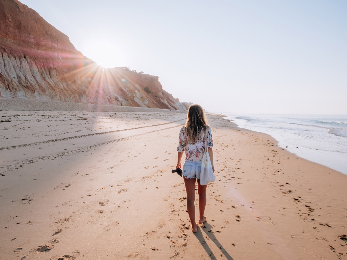 Eine Frau beim Strandspaziergang an der Algarve