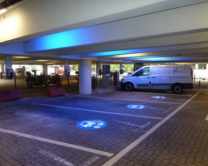 Mit blauem Logo gekennzeichnete Ladestationen für E-Fahrzeuge im Parkhaus P4.