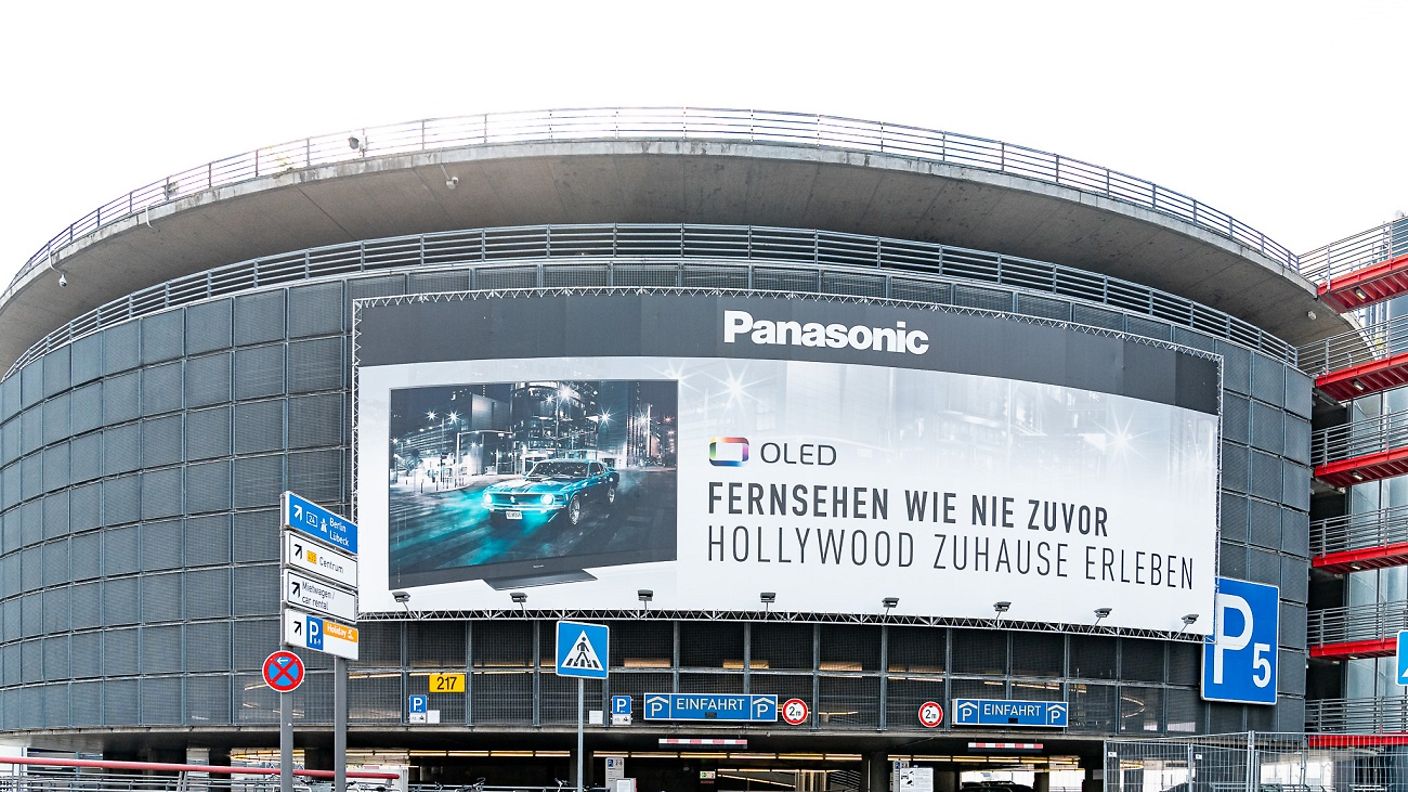 Außenansicht des Parkhauses P5, über dessen Einfahrt eine große Werbefläche installiert ist.