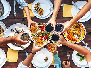 Anstoßen an einem reich gedeckten Tisch mit Essen