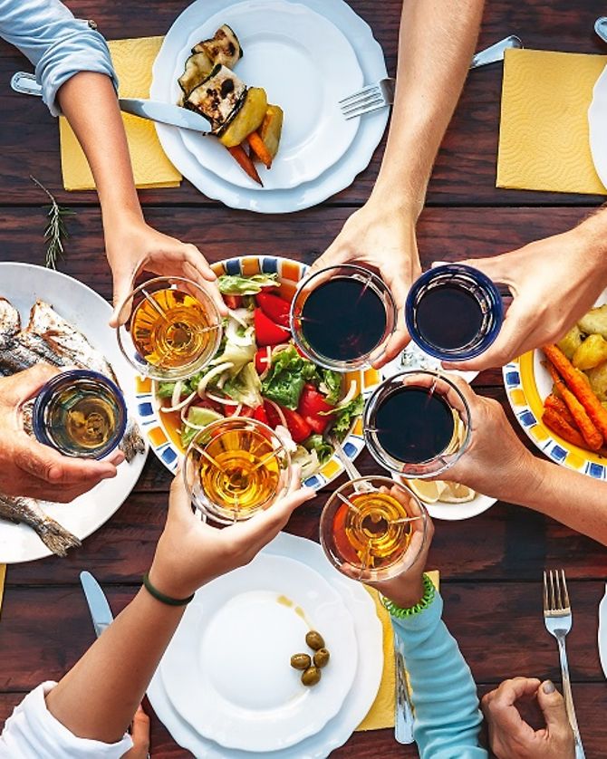 Anstoßen an einem reich gedeckten Tisch mit Essen