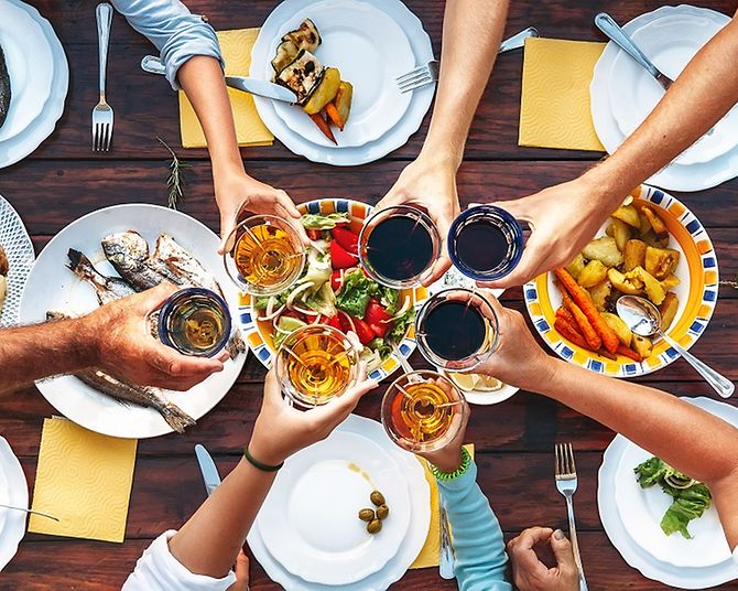 Anstoßen an einem reich gedeckten Tisch mit Essen