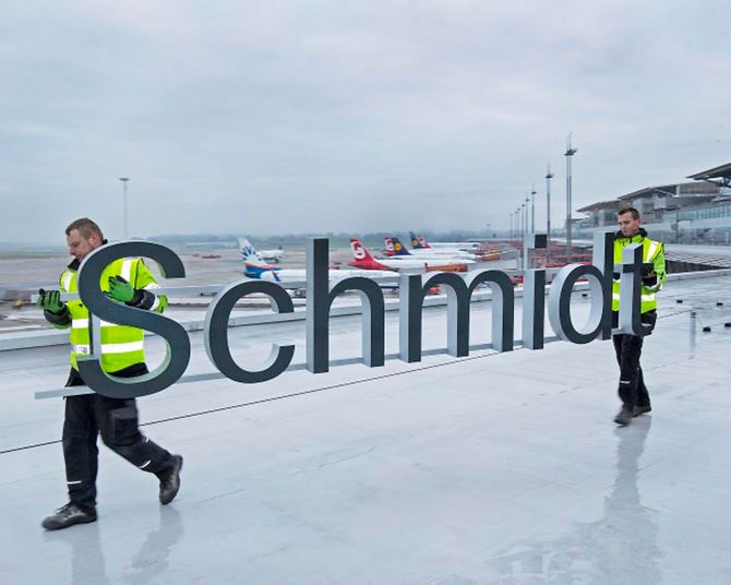 Männer tragen Flughafen-Schriftzug Helmut Schmidt