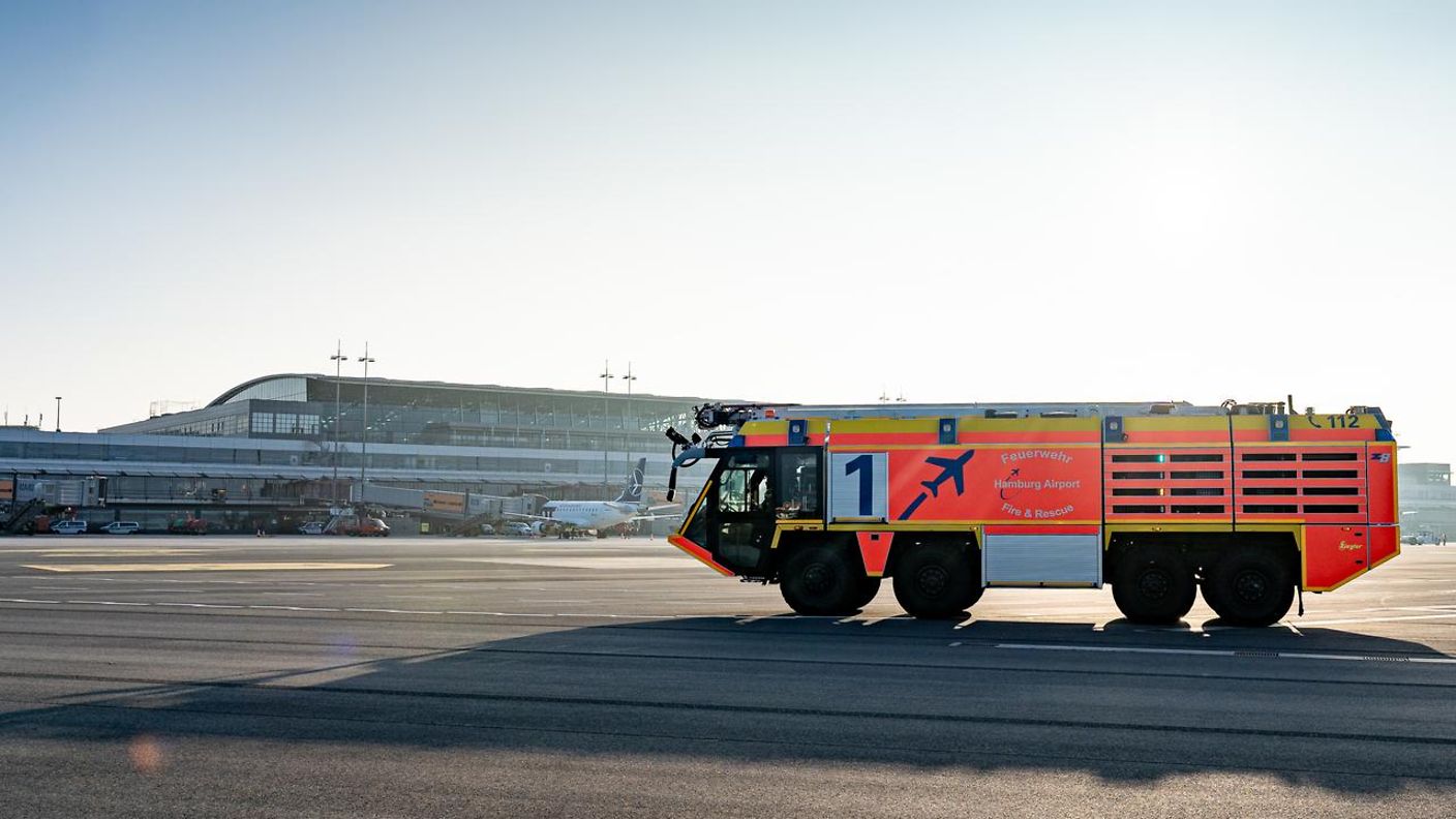 Wasser spritzendes Löschfahrzeug der Flughafenfeuerwehr am Hamburg Airport