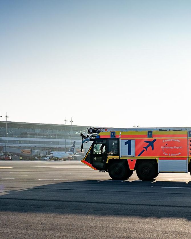 Wasser spritzendes Löschfahrzeug der Flughafenfeuerwehr am Hamburg Airport