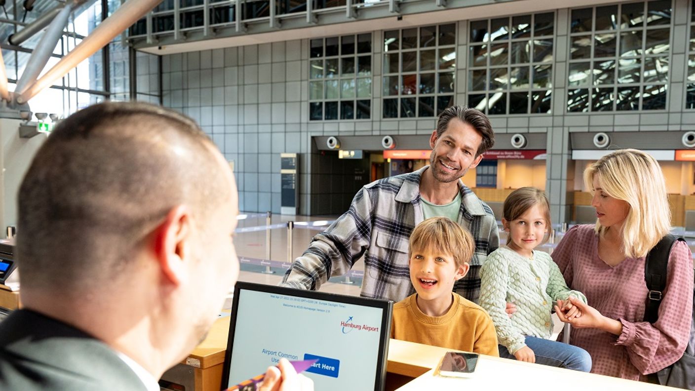 Eine Familie beim Vorabend-Check-in am Schalter am Hamburg Airport