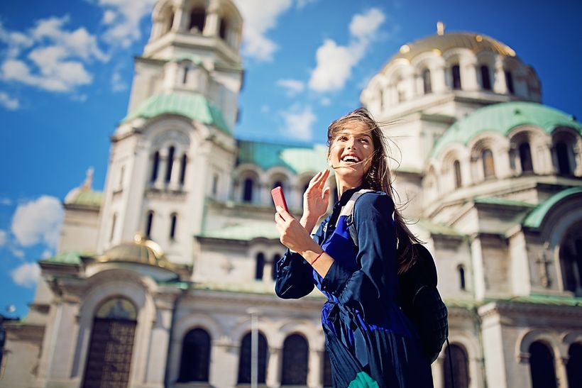 Eine junge lachende Frau vor der Alexander Newski Kathedrale in Sofia.