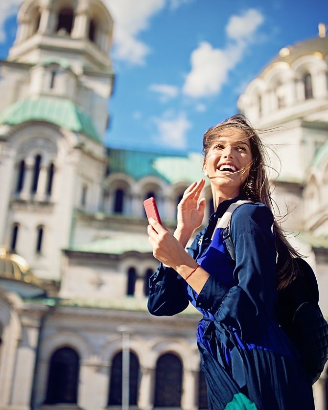 Eine junge lachende Frau vor der Alexander Newski Kathedrale in Sofia.