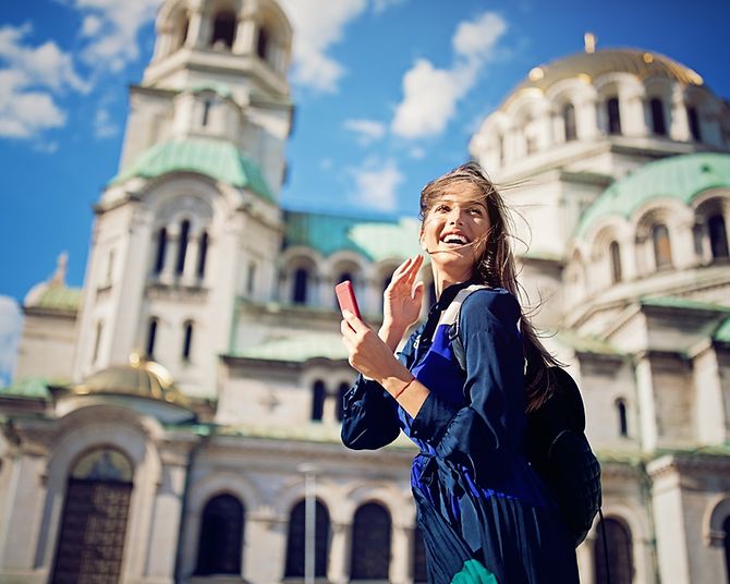 Eine junge lachende Frau vor der Alexander Newski Kathedrale in Sofia.