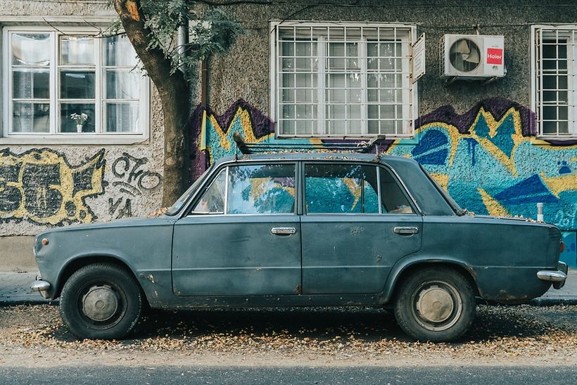 Altes Auto vor einer Hauswand mit Graffiti in Sofia