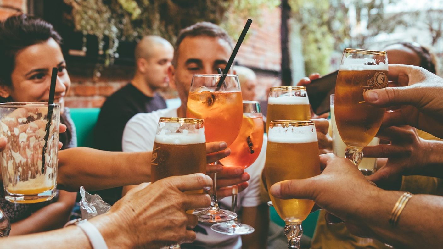 Menschen stoßen mit Gläsern auf einer Terrasse an