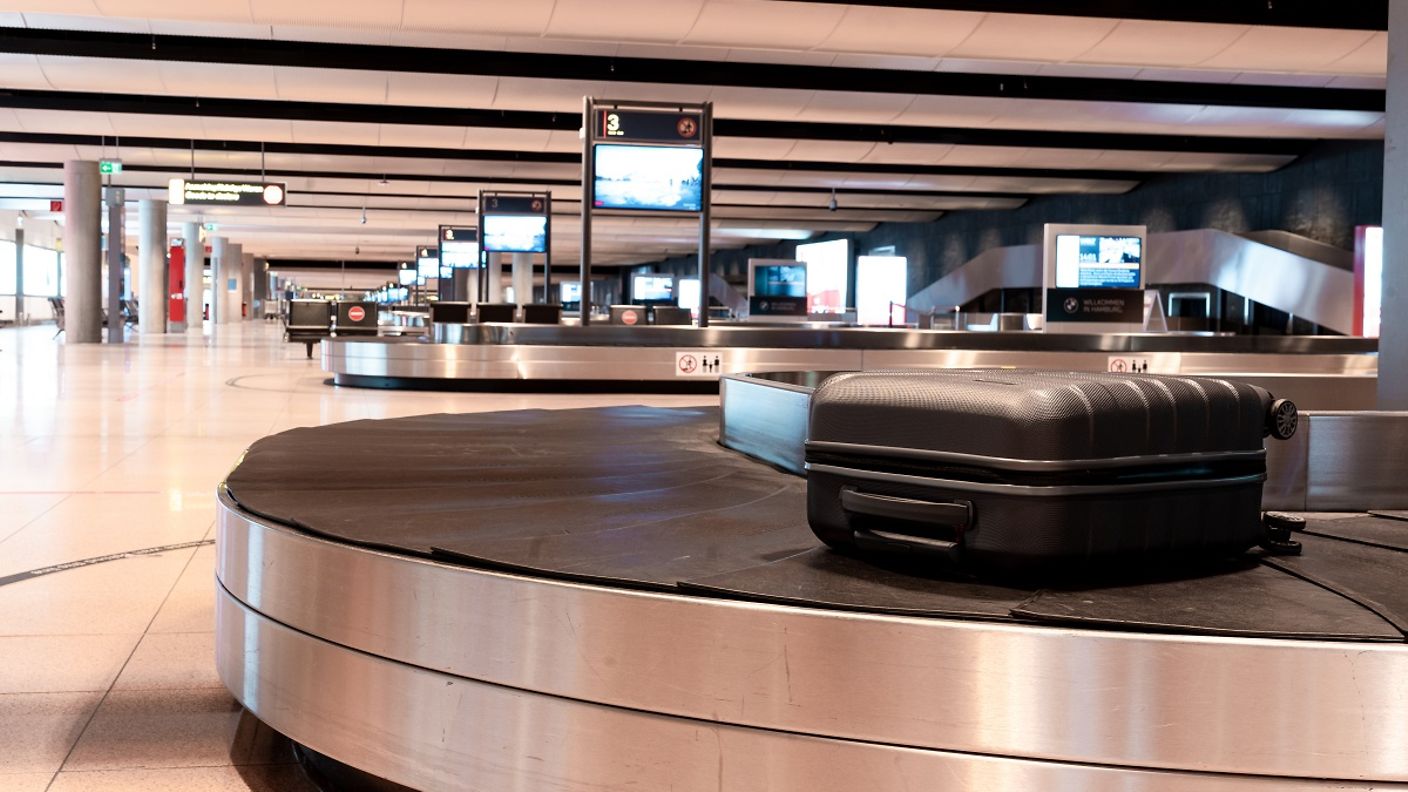 Ein Koffer liegt auf dem Gepäckband im Hamburg Airport