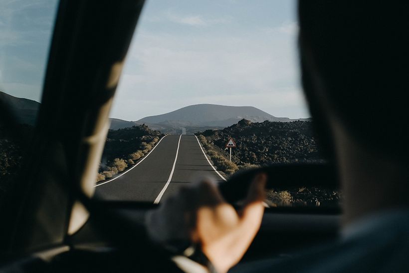 Ein Auto fährt über eine Straße auf Lanzarote