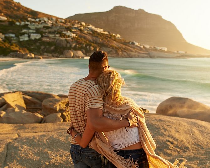 Ein Paar genießt den Sonnenuntergang am Meer