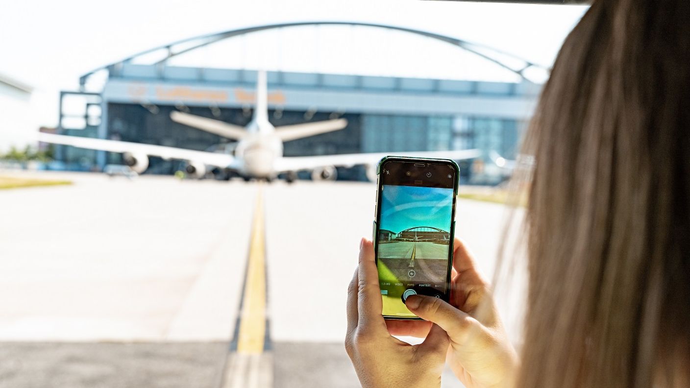 Frau macht mit dem Smartphone ein Foto am Hamburg Airport