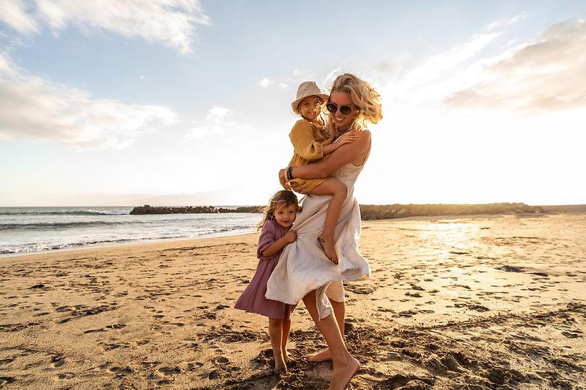 Frau mit Kindern am sonnigen Strand