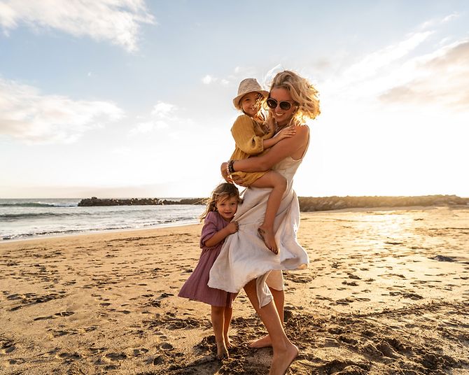 Frau mit Kindern am sonnigen Strand