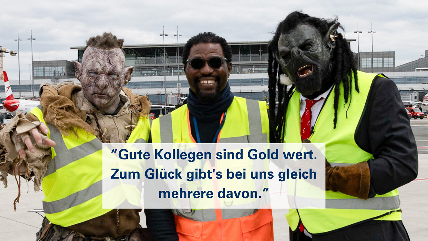 Mitarbeiter und Orks in Warnwesten mit dem Slogan „Gute Kollegen sind Gold wert. Zum Glück gibt’s bei uns gleich mehrere davon.“