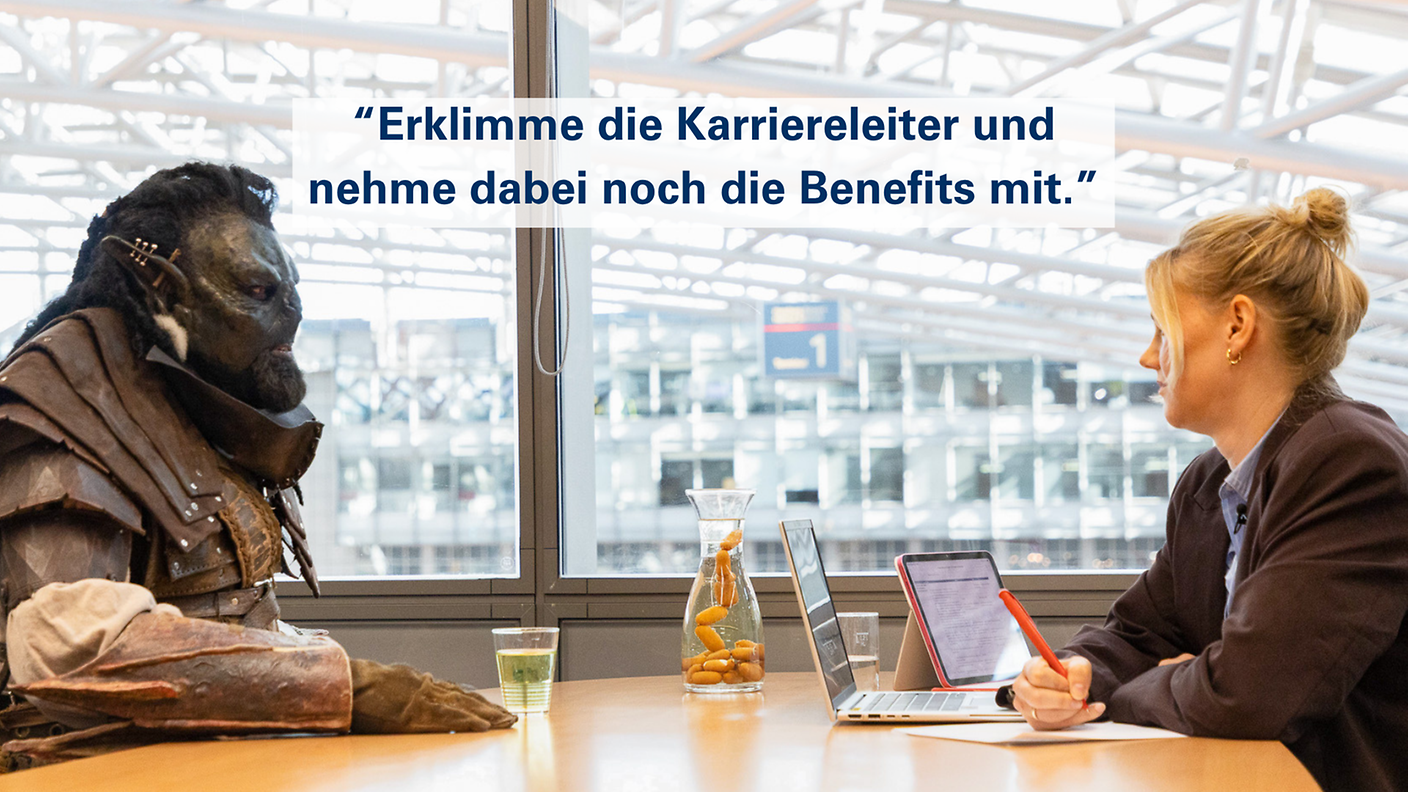 Mitarbeiterin und Ork im Bewerbungsgespräch mit dem Slogan „Erklimme die Karriereleiter und nimm dabei noch die Benefits mit“