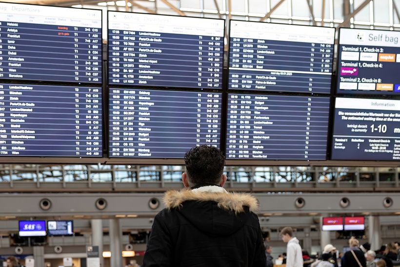 Passagier steht vor der Anzeigetafel im Terminal 1